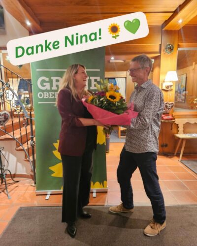 Claus übergibt Nina einen Blumenstrauß