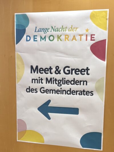 Ein Plakat mit einem Pfeil und der Aufschrift Meet & Greet mit Mitgliedern des Gemeinderates